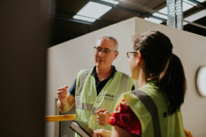 Unilin Insulation man and woman discussing tasks in the factory